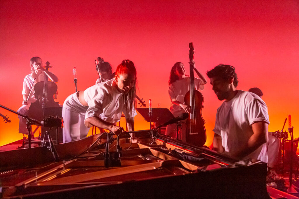 Le groupe sur fond rose avec le pianiste au premier plan