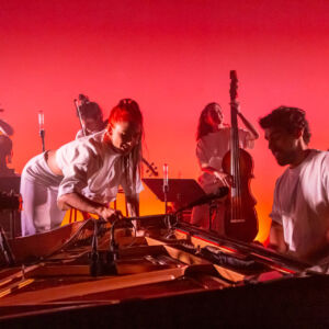 Le groupe sur fond rose avec le pianiste au premier plan