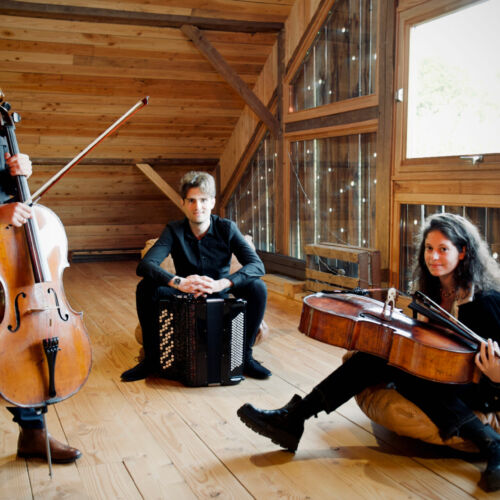 Charles Kieny et ses musiciens posant dans un pièce mansardé avec leurs instruments