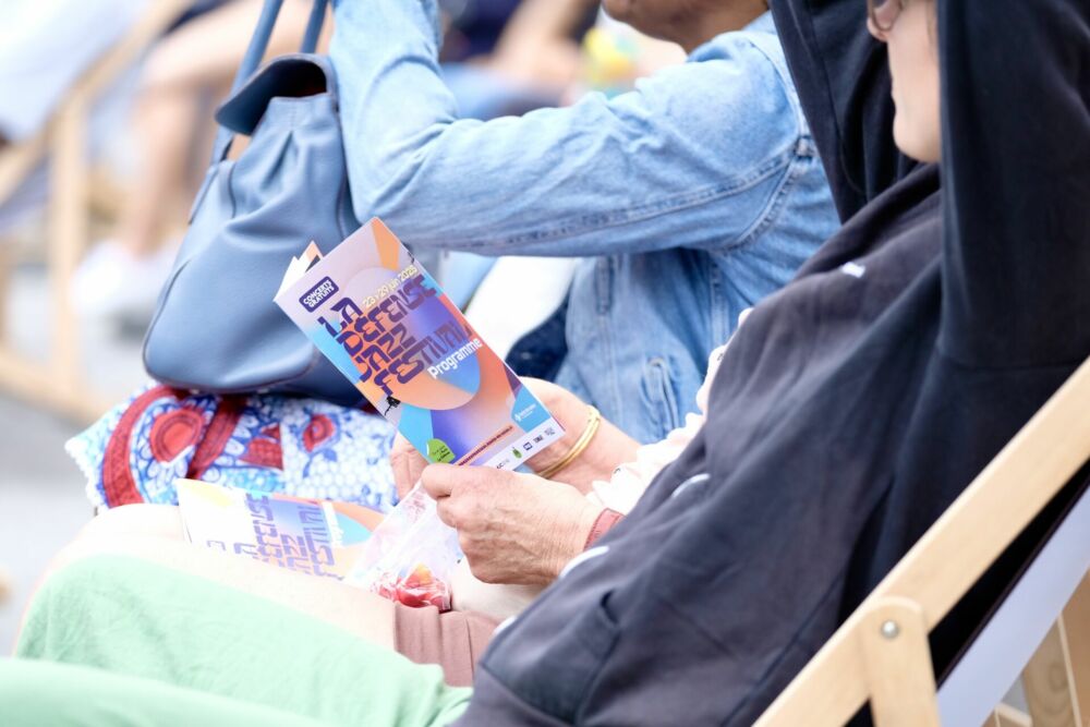Un festivalier tient le programme de l'édition 2025 dans ses mains